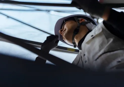 作業員がヘルメットを持ち上げる様子